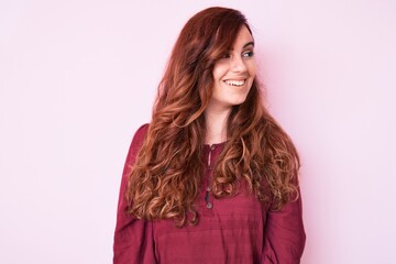 Young beautiful woman wearing casual winter sweater looking away to side with smile on face, natural expression. laughing confident.