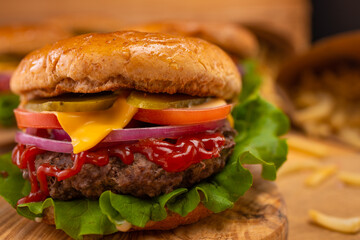 Macro shot of juicy appetizing rudy burgers on wooden background. Fast food concept. Restaurant menu. Cookbook. Classic recipe.