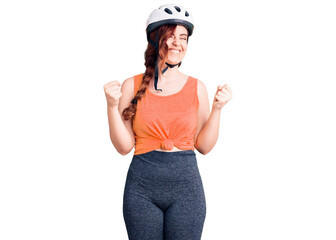 Young beautiful woman wearing bike helmet very happy and excited doing winner gesture with arms raised, smiling and screaming for success. celebration concept.
