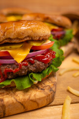 Macro shot of juicy rudy burgers with french potatoes on wooden background. Fast food concept. Restaurant menu. Cookbook. Classic recipe.