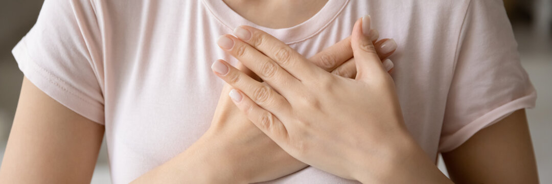 With all my soul. Close up banner image of unknown young female palms folded on chest close to heart in gesture of gratitude appreciation, demonstrating sincere feelings thoughts, symbolizing charity