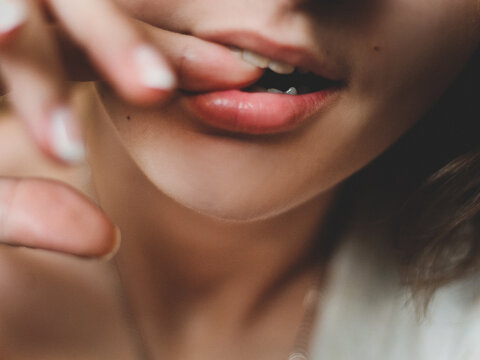 Cropped Image Of Woman Biting Finger