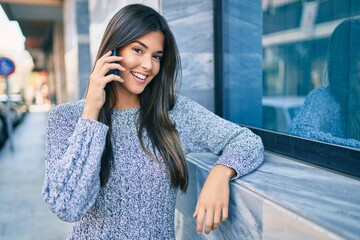 Young beautiful hispanic girl smiling happy talking on the smartphone at the city.