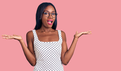 Young african american woman wearing casual clothes and glasses celebrating victory with happy smile and winner expression with raised hands