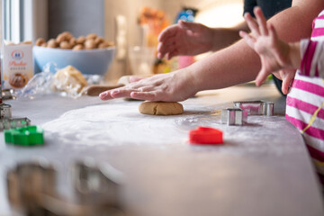 Fototapeta na wymiar Mutter und Kind formen den Teig zum Kekse backen