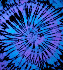 Spiral tie dye texture. Reverse swirl tiedye pattern. Tie-dye background in blue purple.