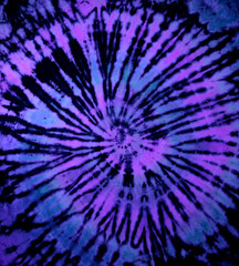 Reverse spiral tie dye in purple blue. Hippie tie-dye pattern texture background wallpaper.