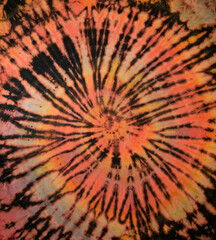 Spiral tie dye texture. Hippie tie-dye wallpaper. Boho festival tiedye background in orange.