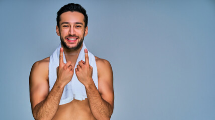 Guy with wide smile with black hair with a beard shows a dental floss  stretched over index fingers. Dental concept