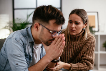 Young man having a problem. Girlfriend comforting her sad boyfriend.