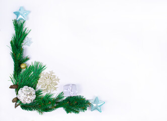 Christmas frame made of pine branches decorated with toys on a white background. Christmas or New Year holiday greeting card.