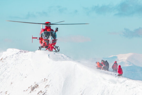A rescue helicopter landing in the snow Swiss alps 