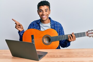 Young handsome african american man learning classical guitar from online tutorial smiling happy...