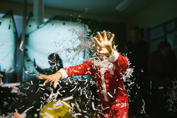 kids playing and having fun with artificial snow at a messy children's Christmas party - 394486516