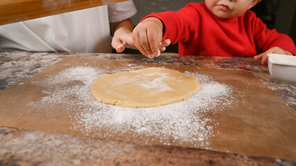 Child's hand pours flour close up