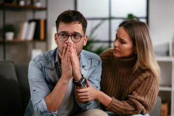 Young man having a problem. Girlfriend comforting her sad boyfriend.