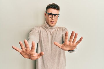 Handsome young man wearing casual winter sweater rejection expression crossing arms doing negative sign, angry face