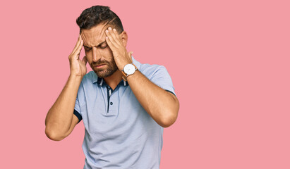 Handsome man with beard wearing casual clothes with hand on head, headache because stress. suffering migraine.