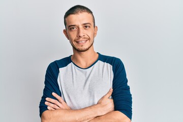 Fototapeta premium Young hispanic man wearing casual clothes shouting with crazy expression doing rock symbol with hands up. music star. heavy concept.