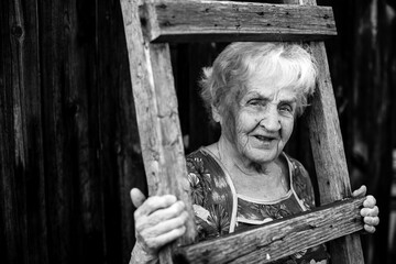 An old woman portrait in the village. Black and white photo.