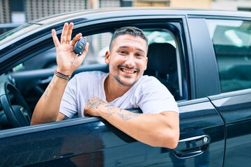 Young hispanic man smiling happy holding key of new car