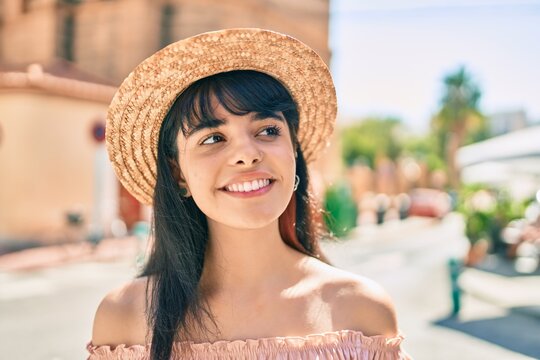 Young hispanic tourist girl wearing summer style walking at the city.