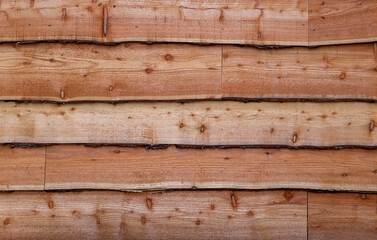 Close up side view of waney edge wooden boards on side of shed
