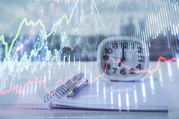 Multi exposure of financial graph drawings and desk with open notebook background. Concept of forex