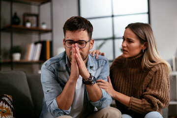 Young man having a problem. Girlfriend comforting her sad boyfriend.