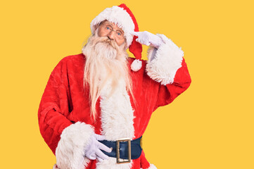Old senior man with grey hair and long beard wearing traditional santa claus costume smiling pointing to head with one finger, great idea or thought, good memory
