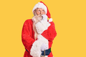 Fototapeta na wymiar Old senior man with grey hair and long beard wearing traditional santa claus costume looking stressed and nervous with hands on mouth biting nails. anxiety problem.