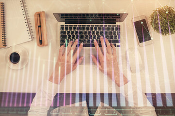 Double exposure of woman hands working on computer and forex chart hologram drawing. Top View. Financial analysis concept.