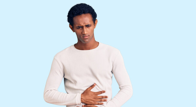 African handsome man wearing casual winter sweater with hand on stomach because indigestion, painful illness feeling unwell. ache concept.