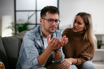 Young man having a problem. Girlfriend comforting her sad boyfriend.
