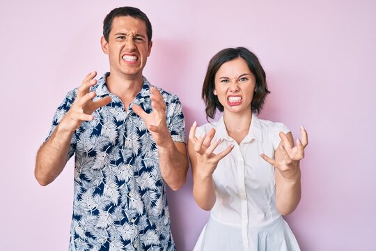 Beautiful couple wearing casual clothes shouting frustrated with rage, hands trying to strangle, yelling mad