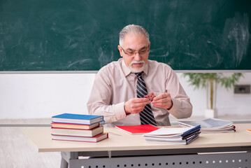 Old male teacher in the classroom