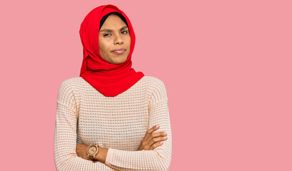 Young african american woman wearing traditional islamic hijab scarf skeptic and nervous, disapproving expression on face with crossed arms. negative person.