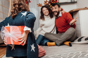 Young father, mother and daughter celebrating New year at their home. Festive family indoors concept.