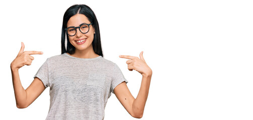 Beautiful young woman wearing casual clothes and glasses looking confident with smile on face,...