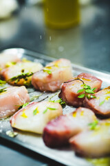 Professional cook puts salt and green ingredients in fish dish
