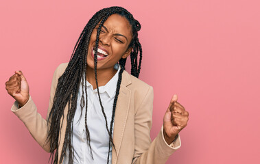 African american woman wearing business jacket very happy and excited doing winner gesture with...
