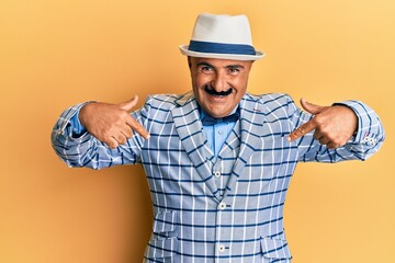Mature middle east man with mustache wearing vintage and elegant fashion style looking confident with smile on face, pointing oneself with fingers proud and happy.