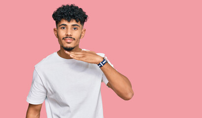 Young arab man wearing casual white t shirt cutting throat with hand as knife, threaten aggression...