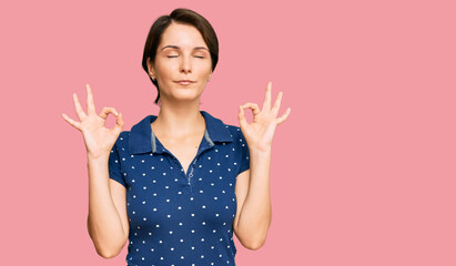 Young brunette woman with short hair wearing casual clothes relax and smiling with eyes closed doing meditation gesture with fingers. yoga concept.