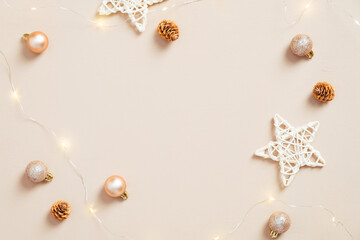 Fototapeta na wymiar Modern Christmas flat lay composition. Elegant balls decorations, stars, cones on pastel beige background. Xmas greeting card mockup. Scandinavian, minimal style.