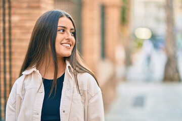 Young hispanic girl smiling happy standing at the city.