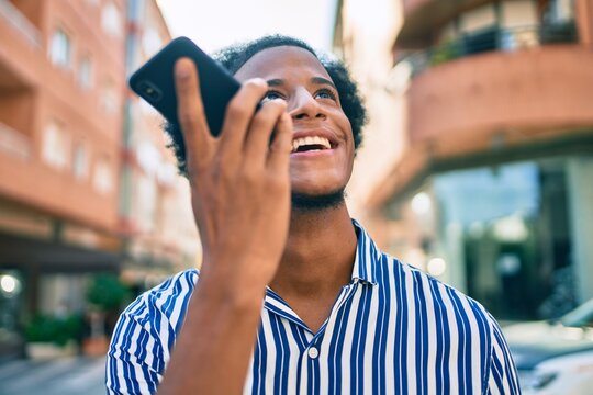 Young african american man smiling happy sending audio message using smartphone at the city.