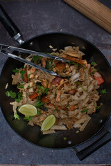 Vegan pad thai made with tofu, seitan, mushrooms and carrot served in wok, copy space