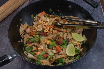 Vegan pad thai made with tofu, seitan, mushrooms and carrot served in wok, copy space