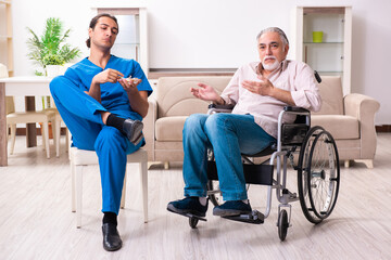 Old man in wheel-chair and young bad caregiver indoors